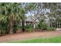 Charming two-story home nestled in a serene, wooded landscape with lush palm trees at 2648 Seabrook Island Rd, Seabrook Island, SC 29455