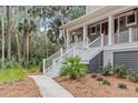 Charming two-story home featuring a welcoming front porch and lush, tropical landscaping at 2648 Seabrook Island Rd, Seabrook Island, SC 29455