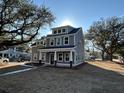 Angle view of a two-story home with gray siding, white trim, and dormer situated on a landscaped lot at 343 Wappoo Rd, Charleston, SC 29407