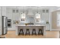 Bright, modern kitchen featuring a large center island, marble backsplash, and stainless steel appliances at 3699 Goodwater St, Mount Pleasant, SC 29466