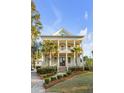 Inviting two-story home boasting double porches, palm trees, manicured landscaping, and a detached garage at 388 Evian Way, Mount Pleasant, SC 29464