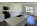 Bright kitchen with stainless appliances, a large island, and a view of the backyard at 4804 Coopers Ct, Summerville, SC 29485