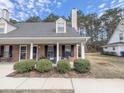 Inviting brick home with covered porch, showcasing rocking chairs and lush landscaping, ideal for relaxing outdoors at 4869 Habersham Ln, Summerville, SC 29485
