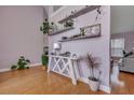 Airy entryway featuring light purple walls, hardwood floors, and decorative shelving with lush plants at 5420 Percival Ln, North Charleston, SC 29420