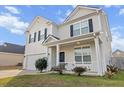 Inviting two-story home showcasing a well-maintained lawn and a cozy front porch with white railings at 615 Ravens Wood Rd, Summerville, SC 29486