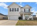 Well-kept two-story home featuring an attached two-car garage and a welcoming front porch with white railings at 615 Ravens Wood Rd, Summerville, SC 29486