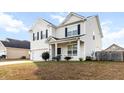 Charming two-story home showcasing a well-manicured lawn and inviting front porch in a neighborhood setting at 615 Ravens Wood Rd, Summerville, SC 29486