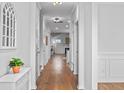 Bright hallway featuring hardwood floors, white walls and trim and a decorative mirror at 625 Sienna Way, Summerville, SC 29486