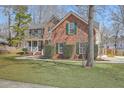 Two-story brick home featuring a spacious front yard, green shutters, and inviting porch at 659 Hamlet Cir, Goose Creek, SC 29445