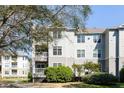 Three-story condominium with white siding, balconies, manicured bushes, and a well-maintained lawn at 700 Daniel Ellis Dr # 5302, Charleston, SC 29412