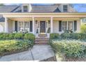 Inviting front porch with stylish columns, lush landscaping, and a decorative front door at 726 Gypsy Ln, Mount Pleasant, SC 29464