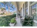Relaxing front porch features comfortable seating and views of the surrounding neighborhood at 726 Gypsy Ln, Mount Pleasant, SC 29464