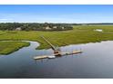 Aerial view of a dock with gazebo and a boat in a marsh waterfront community at 8255 Chisolm Plantation Rd, Edisto Island, SC 29438