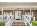 Inviting front porch with brick steps, rocking chairs, and a ceiling fan at 8615 Arthur Hills Cir, North Charleston, SC 29420