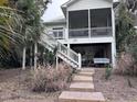 Charming coastal home with wooden stairs and lush tropical plants and fauna surrounding the house at 1001 Jungle Shores Dr # 1/4 Share Interval, Edisto Beach, SC 29438