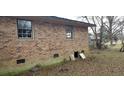 Brick house with outdoor access, showing foundation vents, and a partial view of the surrounding yard and landscape at 1097 Murrell Block Dr, Pineville, SC 29468