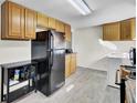 View of kitchen with wood cabinets and appliances next to a full sized black refrigerator at 111 A Heatley St, Moncks Corner, SC 29461