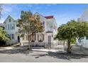 Charming two-story home featuring a wrought iron fence, second story porch, and a beautifully landscaped yard at 12 Percy St, Charleston, SC 29403