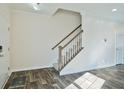 Bright entryway featuring wood-look floors and a staircase with white risers and a wood railing at 122 Rockingham Way, Moncks Corner, SC 29461