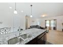 Open concept kitchen with island, stainless steel sink, and view to the living room at 122 Rockingham Way, Moncks Corner, SC 29461
