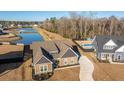 Aerial view of a well-maintained home with lush lawn, long driveway and a backyard pool nearby at 130 Darby Mdw Ln, Ridgeville, SC 29472