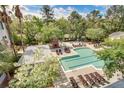 Aerial view of a community pool surrounded by lounge chairs, landscaping, and a grilling area under sunny skies at 130 River Landing Dr # 6207, Charleston, SC 29492