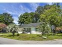 Charming single-story home features a brick facade, dark roof, palm trees, and well-maintained lawn at 1520 Wakendaw Rd, Mount Pleasant, SC 29464