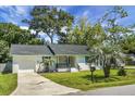 Charming, single-story home features a brick facade, dark roof, palm trees, and well-maintained lawn at 1520 Wakendaw Rd, Mount Pleasant, SC 29464