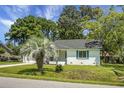 Charming single-story home features a brick facade, dark roof, palm trees, and well-maintained lawn at 1520 Wakendaw Rd, Mount Pleasant, SC 29464