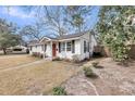 This cozy home displays white siding, black shutters and a lovely manicured lawn at 17 Anita Dr, Charleston, SC 29407