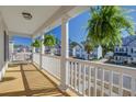 Relaxing covered balcony with white railing offering neighborhood views and hanging plants at 1945 Hubbell Dr, Mount Pleasant, SC 29466