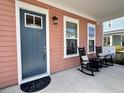 Inviting front porch featuring rocking chairs, a stylish door, and attractive, neutral exterior at 2014 Codorus Ln, Hanahan, SC 29410