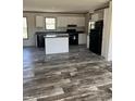 Modern kitchen featuring sleek black appliances, stylish wood-look flooring, and bright white cabinets with plenty of counter space at 286 Marion Rd, Dorchester, SC 29437