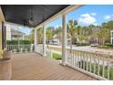 Relaxing covered porch with wood flooring and views of the neighborhood street and lush trees at 2876 Rivertowne Pkwy, Mount Pleasant, SC 29466
