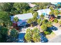 Aerial view of a pink two-story home surrounded by lush palm trees and manicured landscaping at 3 25Th Ave, Isle of Palms, SC 29451