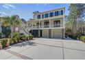 Charming two-story home with a spacious double porch, double garages, and a long driveway surrounded by lush landscaping at 3575 Holmgren St, Mount Pleasant, SC 29466