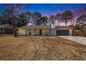 A charming one story home with a well manicured yard, illuminated by an enchanting dusk sky at 402 Woodward Blvd, Summerville, SC 29483