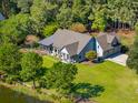 Beautiful home with a well-manicured lawn, mature trees, and outdoor seating at 4105 Gnarled Oaks Ln, Johns Island, SC 29455