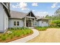 Inviting home featuring a covered porch and a manicured yard with fresh landscaping at 4105 Gnarled Oaks Ln, Johns Island, SC 29455