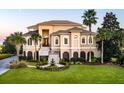 Beautiful home featuring manicured lawn, stately palm trees, and classic architectural elements at 4935 Sound View Dr, Mount Pleasant, SC 29466