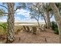 Cozy outdoor fire pit area with Adirondack chairs and views of the marsh at 4935 Sound View Dr, Mount Pleasant, SC 29466