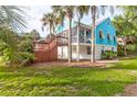 Backyard showcasing lush green lawn and mature palm trees surrounding the quaint blue home at 5 25Th Ave, Isle of Palms, SC 29451