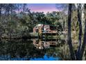 Charming home reflects on the water, surrounded by trees under sunset at 5219 Maybank Hwy, Wadmalaw Island, SC 29487