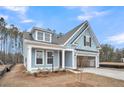Charming light blue home featuring an attached two-car garage, a covered porch, and a gabled roof at 429 Grove End Rd, Moncks Corner, SC 29461