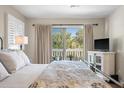 Bright bedroom with sliding glass doors to balcony with views of tropical trees at 8 Lagoon Villas, Isle of Palms, SC 29451