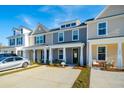 Inviting townhome exterior with covered porch, parking, and craftsman details at 814 Alma Square Dr, Moncks Corner, SC 29461