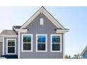 A sunny, close-up exterior view highlights the home's architectural details and window placement at 818 Alma Square Dr, Moncks Corner, SC 29461