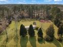 Expansive aerial view of a property featuring a well-maintained lawn, mature trees and a cozy house at 835 Gross Ave, Moncks Corner, SC 29461