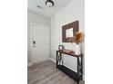 Neutral foyer with decorative console table, wood-look flooring, and a front door at 8816 Kellum Dr, North Charleston, SC 29420