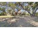 Large backyard with mature trees, a lush lawn, and a detached garage, perfect for outdoor enjoyment and storage at 1042 Chambers Ln, Mount Pleasant, SC 29464